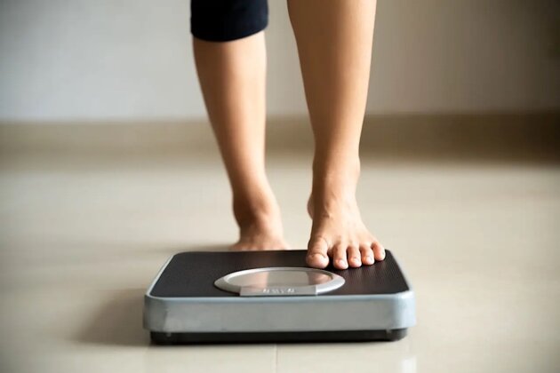 Female leg stepping on weigh scales. Healthy lifestyle, food and sport concept. Female leg stepping on weigh scales. Healthy lifestyle, food and sport concept.
